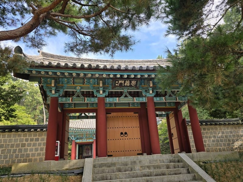 소나무와 돌계단에 둘러싸인 부소산성 삼충사 충의문