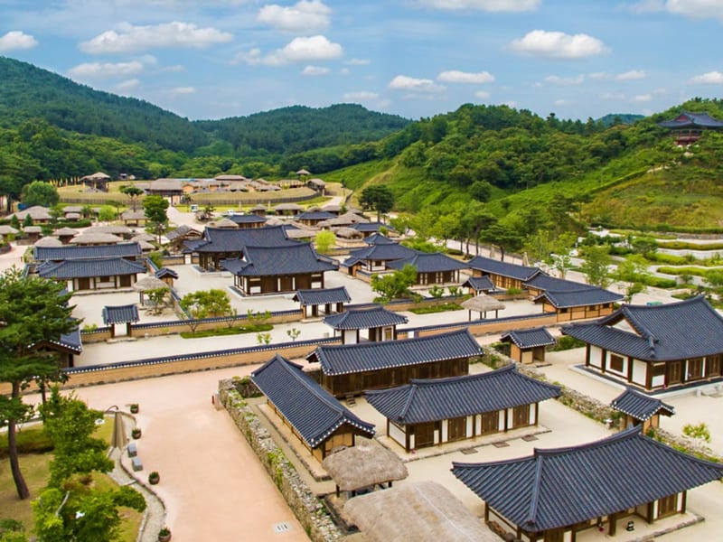 산과 나무 사이에 기와집과 초가집이 펼쳐진 백제문화단지 생활문화마을